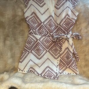 Cream colored romper by Moon River with red pattern in size medium.